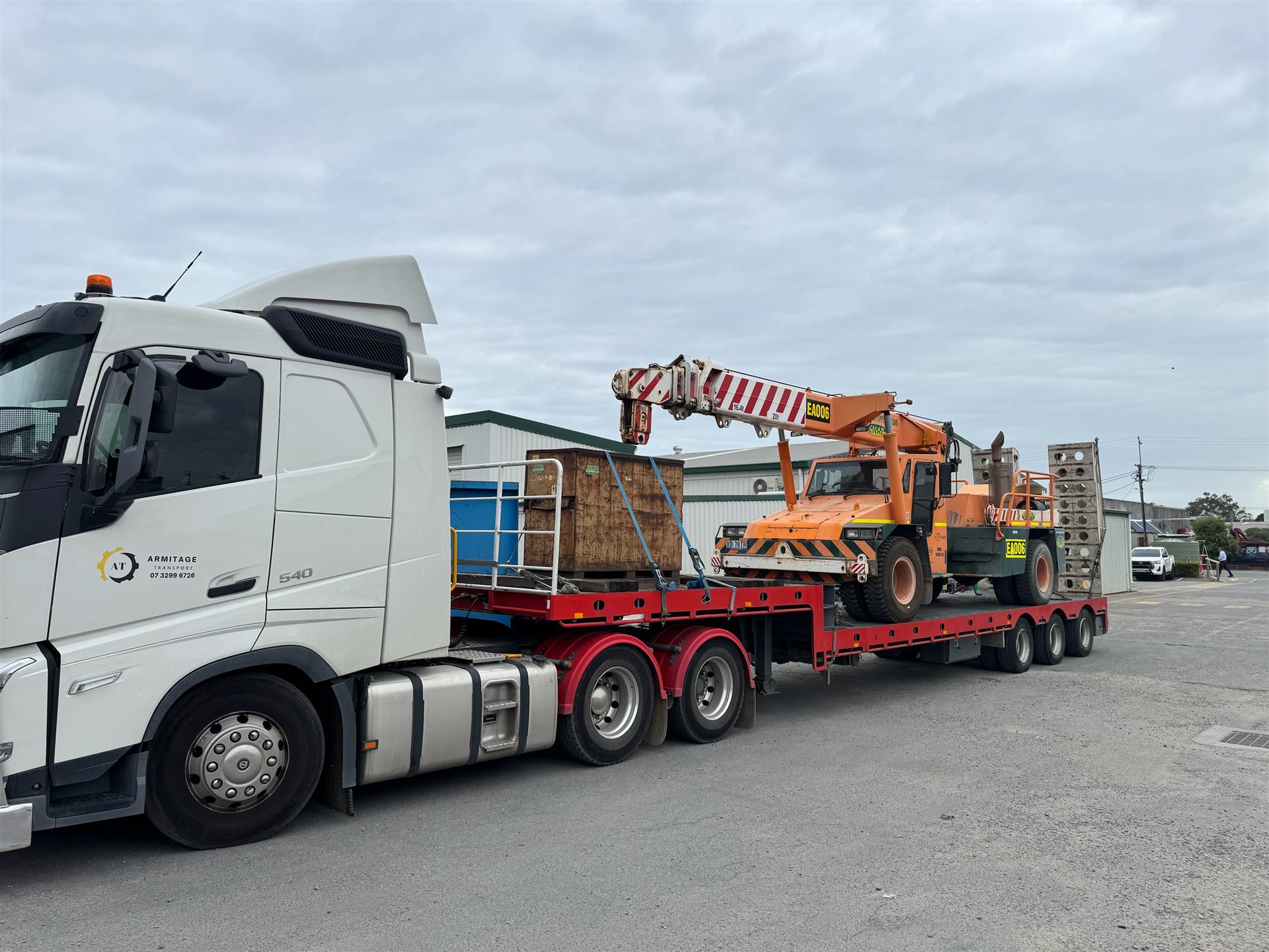 Armitage Transport truck transporting a mobile crane and machinery